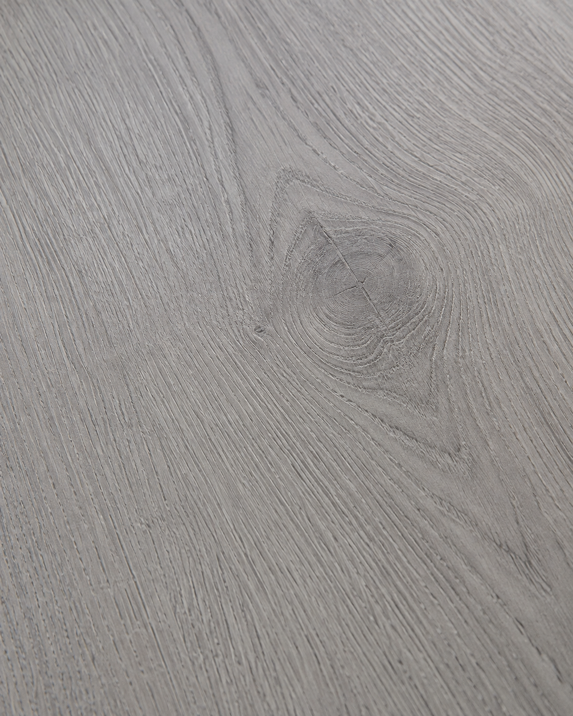 A close-up of a light gray wood grain surface with visible natural-looking grain patterns and a small knot.